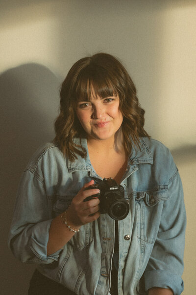Marissa Rosenbaum, Montana wedding photographer, posing with camera in hand in Butte, Montana