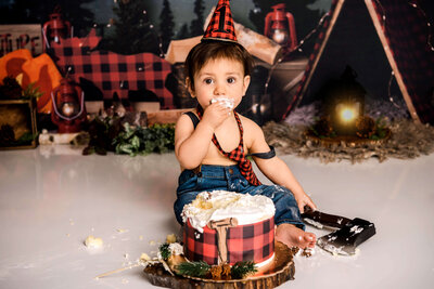 Portrait Photographers CT create memorable lumberjack first birthday photos with baby in plaid suspenders and party hat