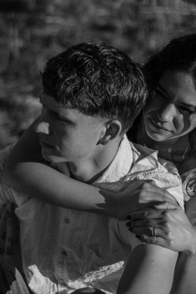 Elizabeth hugging David from behind, in black and white.