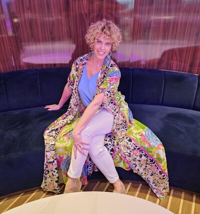 personal vacation planner GG Mack sitting on a couch smiling