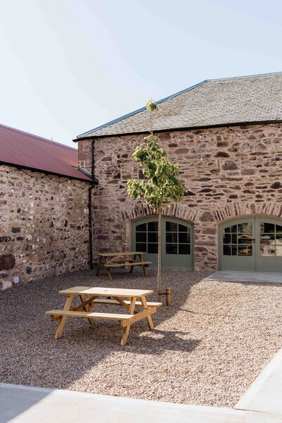 An old barn courtyard at Kinclune House is photographed. The space is newly renovated.