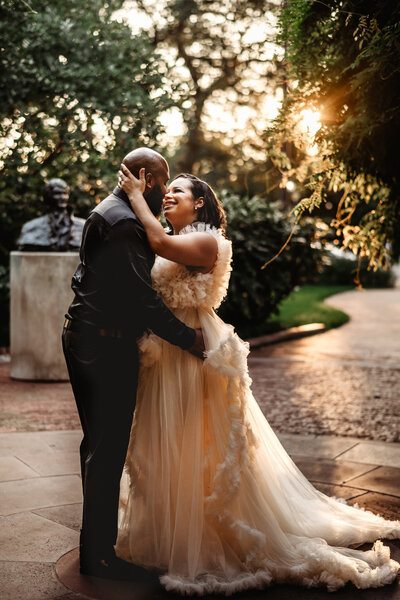 Elegant wedding with bride and a cream wedding dress dancing with her groom who is wearing all black and a courtyard for their outdoor Baltimore wedding captured by Maryland wedding photographer