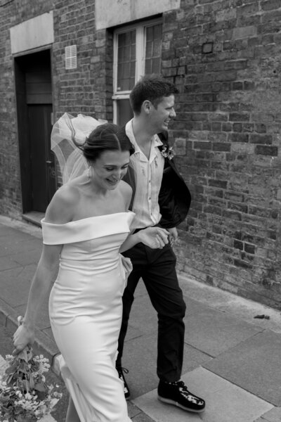 Bride and groom walk hand in hand at their Cotswold wedding