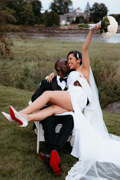 Boston Wedding - Interracial couple sitting outside of their venue. Both with christian louboutin shoes on