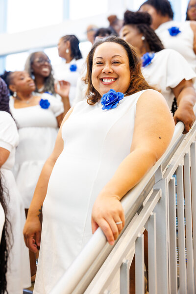 A woman smiling while standing with a group at a sorority event