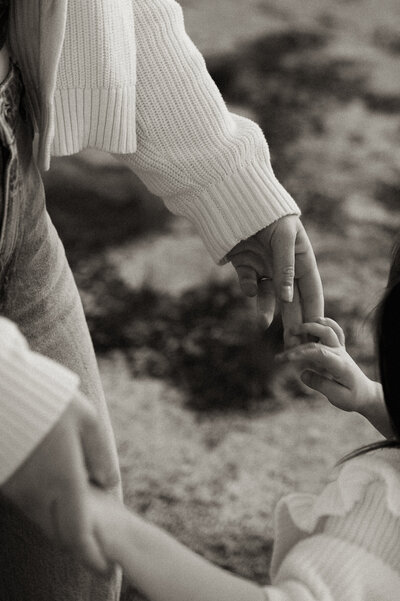 Em from Zephyr Digital Photography holding her daughter's hands