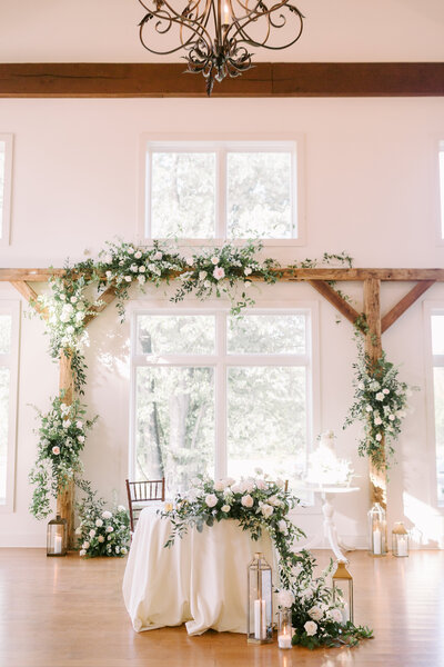 Romantic wedding table setting with detailed floral centerpieces and delicate accents, styled by Leigh Florist.