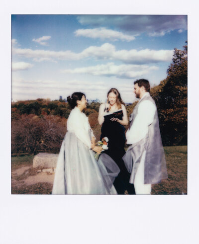 Close up of wedding invitation and other meaningful parts of the wedding, laid out on a table