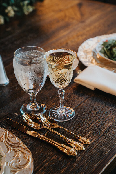 Image of crystal glassware and vintage silverware next to a vintage Hermes dinner plate