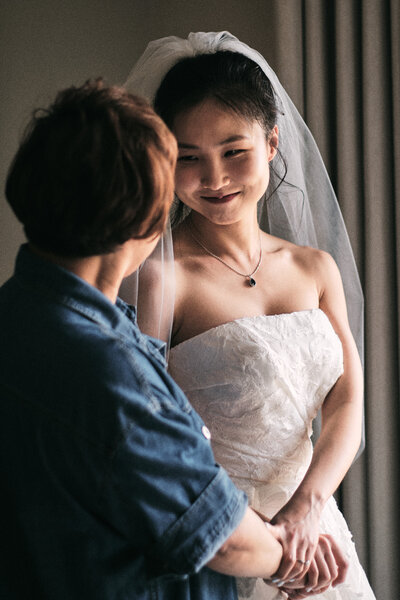 Mother looks at her daughter lovingly in her wedding dress