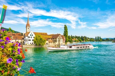 Historic European building on a river with a boat, planned by concierge travel services GG Mack