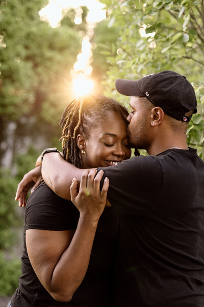 Couple embracing with the sunset behind them.