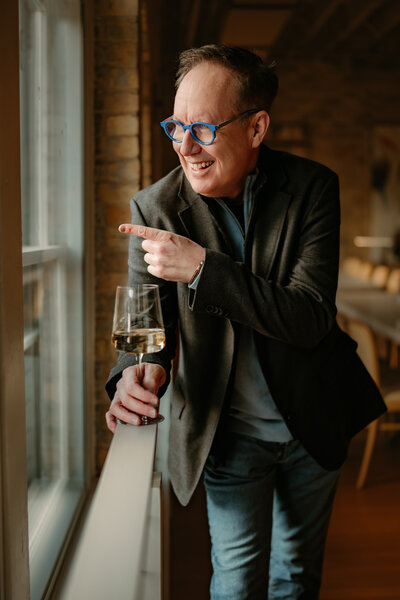 Confident man laughing with a wine glass during a Minneapolis online dating photo session by Shannon Kathleen Photography.