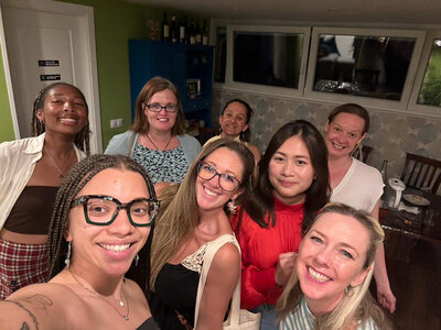 A group of female guests posing with Maria Cristina during their private wine tasting.