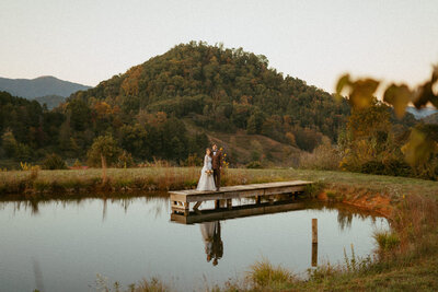 asheville wedding couple standing on dock in front of mountain