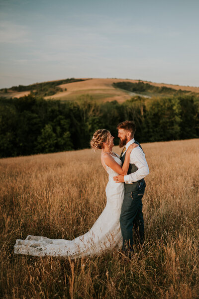 Bride and Groom in field for portrait at sunset