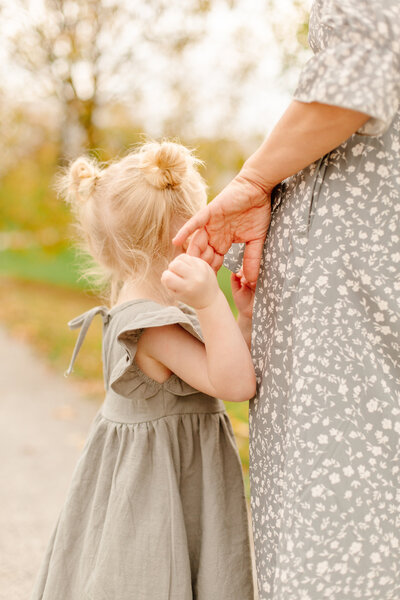 Little girl holding mom's hand