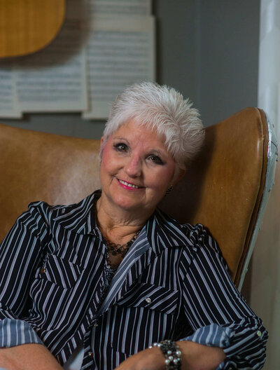 Headshot of Tammy O'Neil sitting in a striped shirt