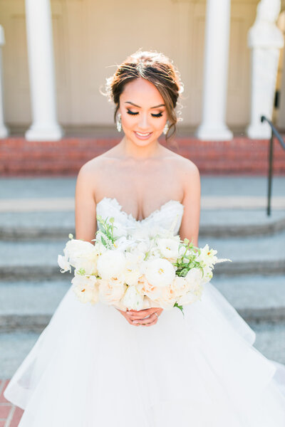 bride holding her bouquet for a portrait in the courtyard of la pietra