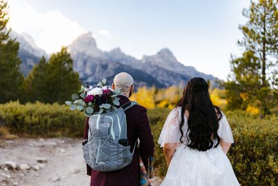 A couple hiking to Taggart Lake in Grand Teton National Park after their elopement