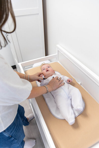 Woman with her baby on a changing table