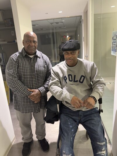 two men standing in hallway smiling