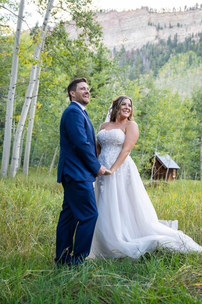 a bride and groom in the Colorado rocky mountains holding hands