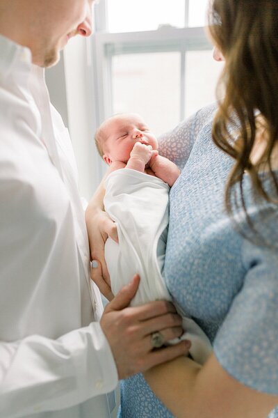 Katelyn Ng Photography, Indianapolis Newborn photographer, photographed a father and mother holding their son.