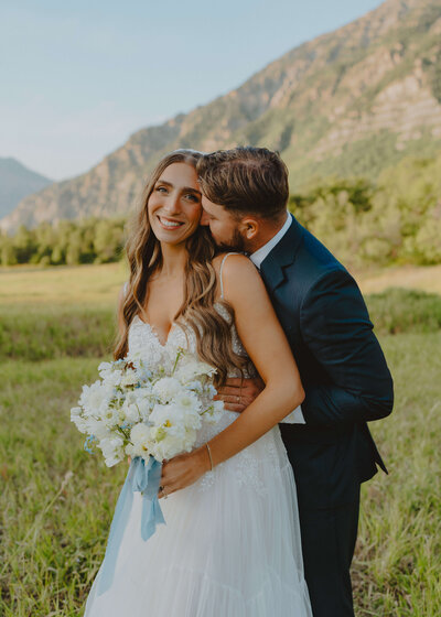 groom leaning over bride against door