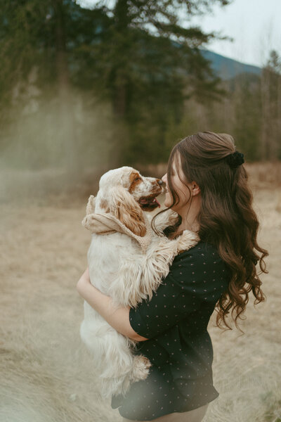 portrait of a girl with long hair holding an english cocker spaniel