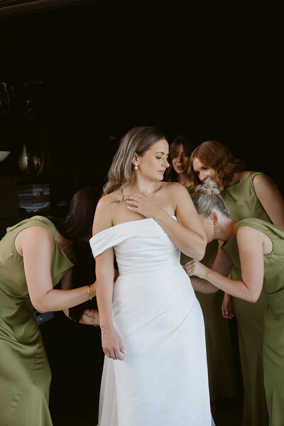 bride and bridal party getting in dress for wedding in new zealand