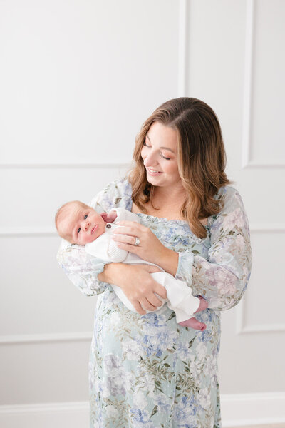 Mom holding her newborn baby boy in a northern kentucky newborn photography studio