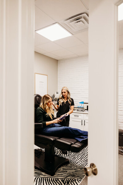 Woman sitting in a chair chatting with a nurse practitioners