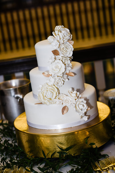 White and Gold Wedding cake on gold cake plateau at Biloxi Visitors Center, Biloxi, MS Wedding