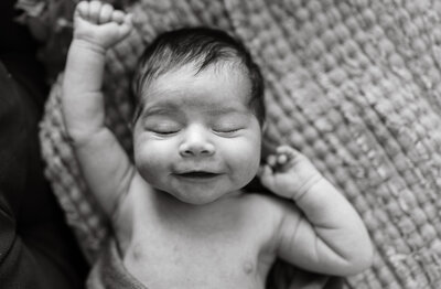 Newborn baby stretching during in home session by Taylor Lynn Studios