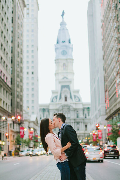 A couple kissing in the middle of a city street 