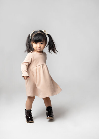 Young girl in pale pink dress and black boots