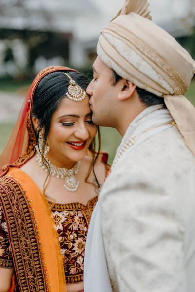 Groom kissing bride forehead at Raleigh wedding