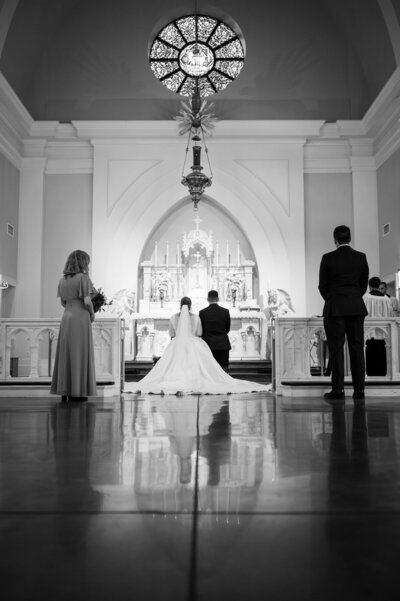 A couple kneel before the altar at their Latin Mass Catholic Wedding in Hampton Roads Virginia, taken by Nathan Sottung Photography