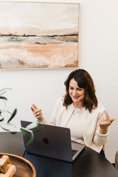 Dena using her laptop for a virtual therapy session