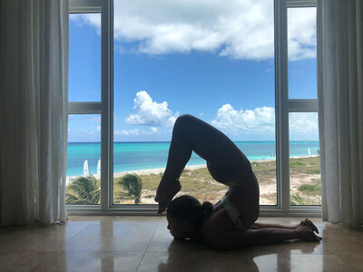 Luxury Travel Concierge for Greece, girl doing handstand in front of white church