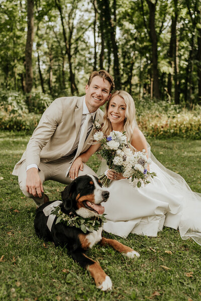 bride and groom smiling with their dog