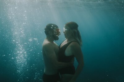 Couple holding each other underwater
