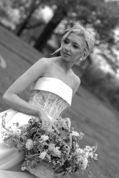 Bride holding her wedding bouquet, showcasing her beautiful flowers in a close-up shot, captured in a soft, elegant moment.