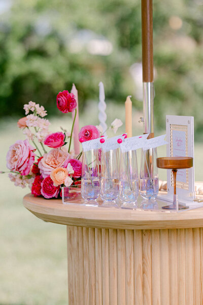 A simple yet charming display of nature and tranquility, featuring glasses of water and a lovely arrangement of flowers on a wooden table during a wedding reception.