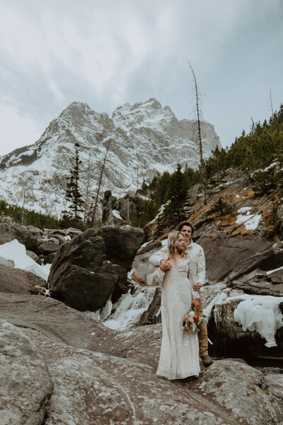 Cinematic elopement filmmaker capturing an adventurous couple in a breathtaking mountain landscape.