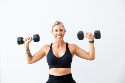 A personal trainer guiding a client through a workout, focusing on individualized fitness programs for women.