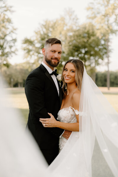 Outdoor Tennessee wedding ceremony with floral arch and golden hour lighting