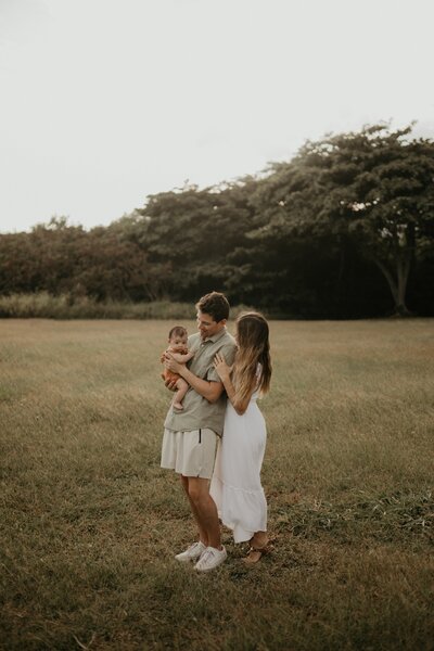Wedding Photographer and Videographer Gabriel Howard standing in a field with child and wife
