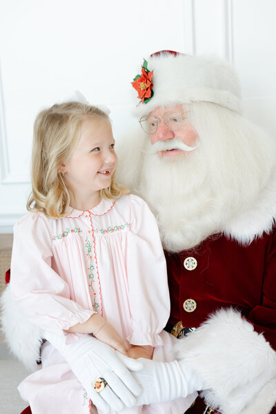 Child sitting on Santa's lap for pictures with Santa in Tulsa